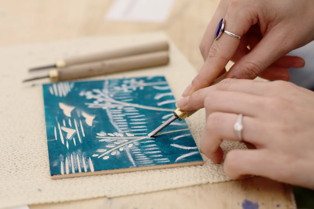 Carving a woodcut design with a gouge